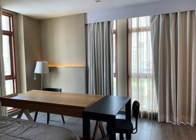 Bedroom with desk and large windows