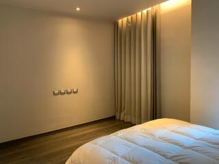 Modern minimalist bedroom with cozy lighting and thick curtains