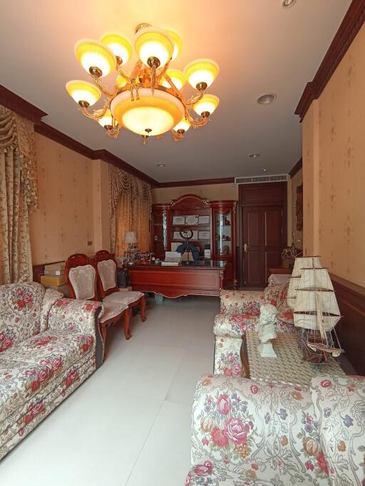 Elegantly furnished living room with floral sofas and chandelier