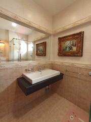 Bathroom with a wall-mounted sink and decorative artworks