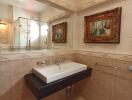 Bathroom with a wall-mounted sink and decorative artworks