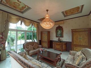 Elegant and well-furnished living room with a chandelier and large windows