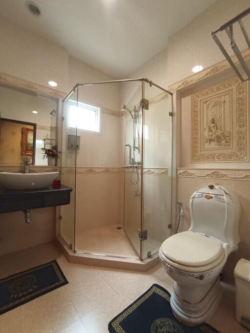 Elegant bathroom with glass shower enclosure and ornate decor