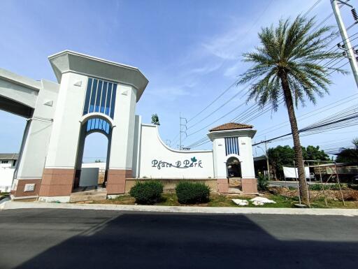 Main entrance gate with palm tree and sign 