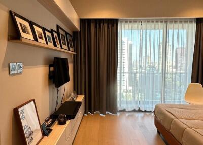 Modern bedroom with city view, wooden floor, and large windows