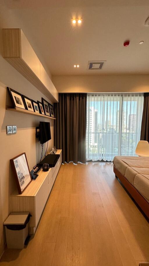 Modern bedroom with city view, wooden floor, and large windows