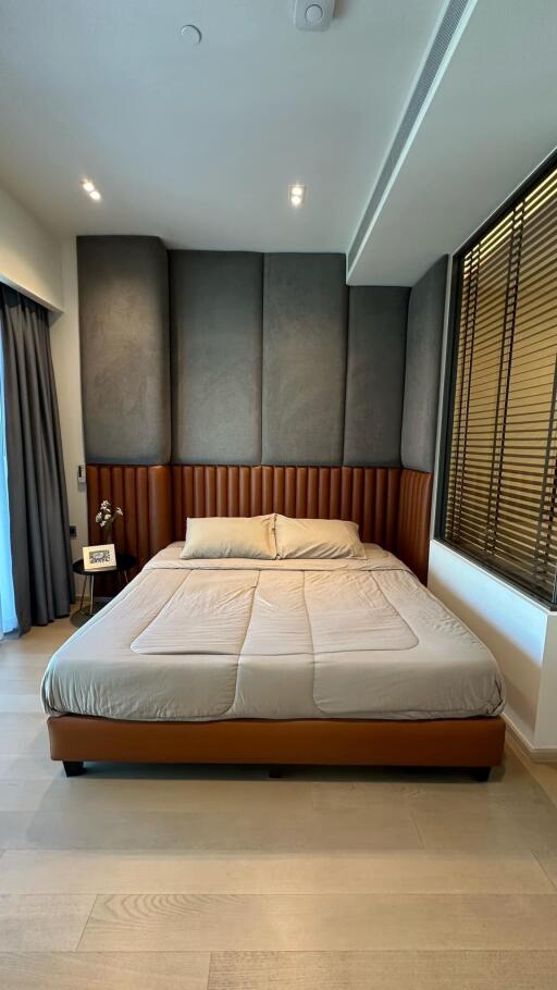 Modern bedroom with padded headboard and large windows