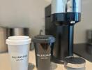 Luxury coffee setup with branded cups and modern coffee machine on counter