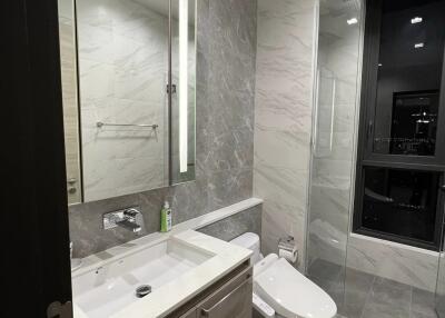 Modern bathroom with a vanity, sink, toilet, and walk-in shower