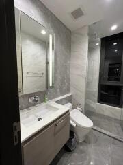 Modern bathroom with a vanity, sink, toilet, and walk-in shower