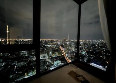 Bedroom with night city view through large windows