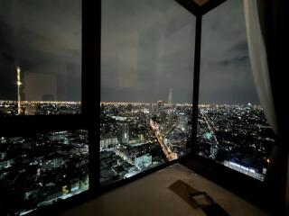 Bedroom with night city view through large windows