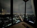 Bedroom with night city view through large windows