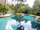 Outdoor pool in a landscaped area with trees and apartment buildings in the background