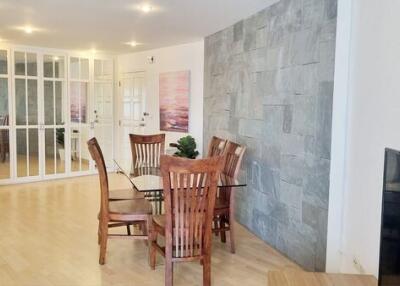 Modern dining area with wooden furniture and glass table