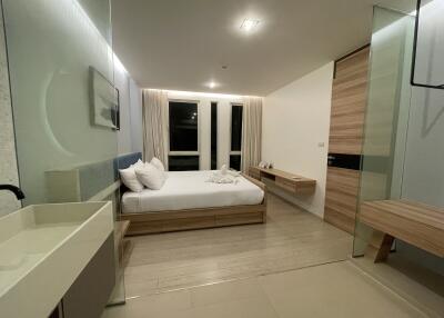 Modern bedroom with minimalist design, large windows, and ambient lighting