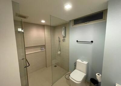 Modern bathroom with shower, toilet, and towel rack