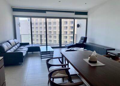 Modern living room with sofa, chairs, and large windows