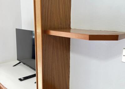 Living room with TV and wooden shelves