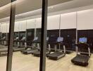 Modern gym with multiple treadmills and large windows