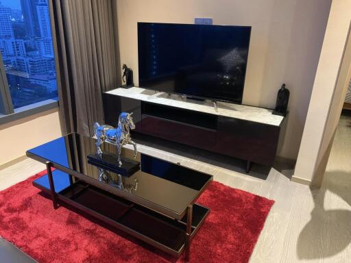 Modern living room with a television, coffee table, and decorative items