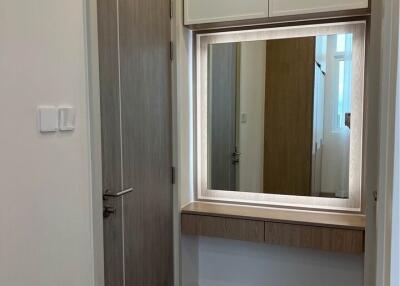 Small hallway with a wall-mounted mirror and storage cabinets