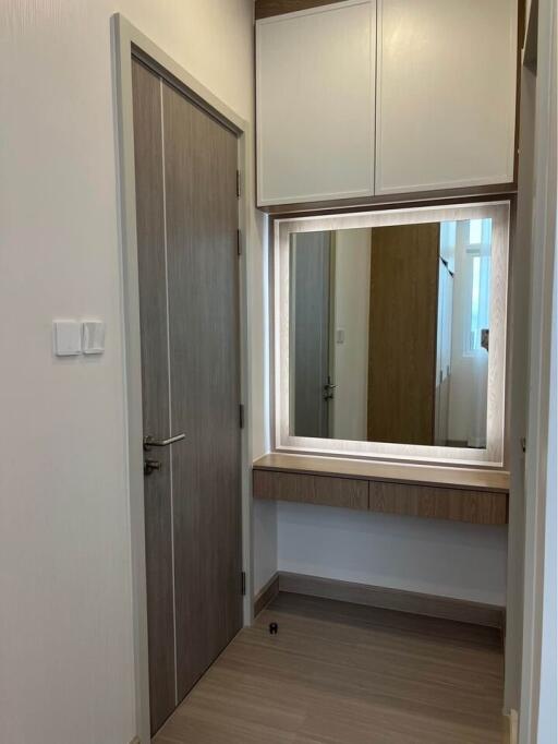 Small hallway with a wall-mounted mirror and storage cabinets