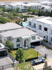 Aerial view of a modern residential house with surrounding neighborhood