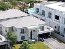 Aerial view of a modern residential house with surrounding neighborhood