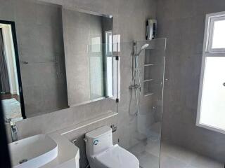 Modern bathroom with glass shower, sink, and toilet