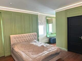 Main bedroom with green paneling and modern furnishings