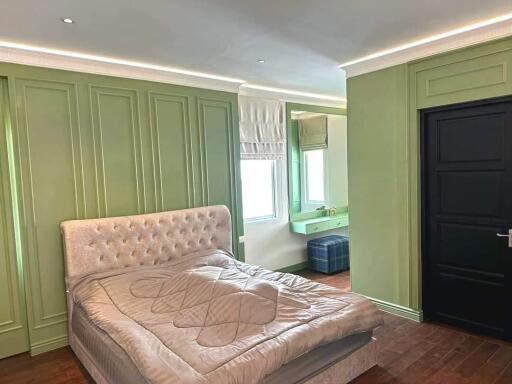 Main bedroom with green paneling and modern furnishings