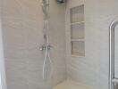 Modern bathroom shower area with built-in shelves