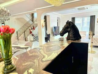 Living room with modern decor including horse head sculpture on the counter.