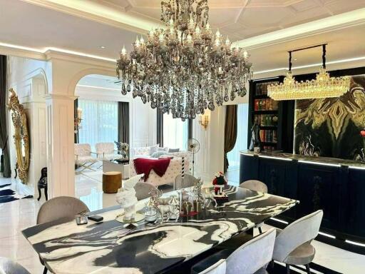 Elegant dining area with chandelier and adjacent living room