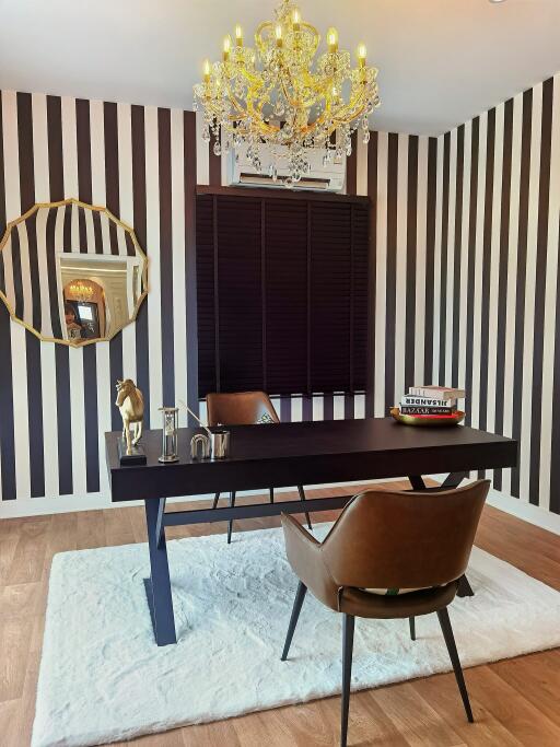 Modern home office with striped wallpaper and chandelier