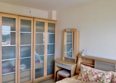 Bedroom with wooden furniture and floral-patterned bed