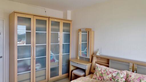 Bedroom with wooden furniture and floral-patterned bed