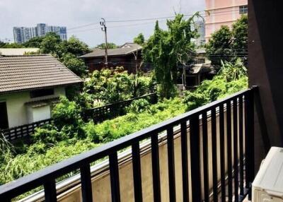 Balcony view with surrounding greenery and neighboring buildings