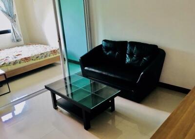 Modern living room with black leather sofa and glass coffee table