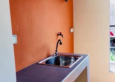 Compact Kitchen with Sink and Orange Backsplash