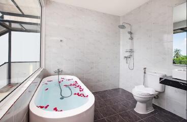 Spacious bathroom with bathtub and shower