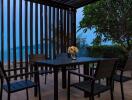 Outdoor patio with a view of the sea, dining table, and chairs