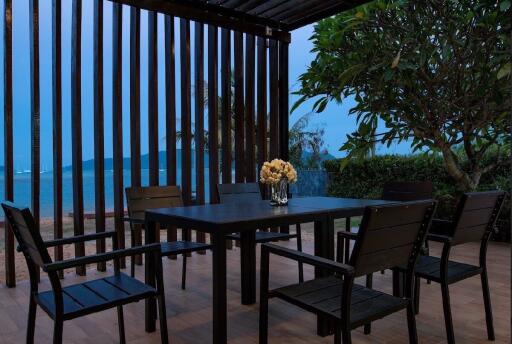 Outdoor patio with a view of the sea, dining table, and chairs