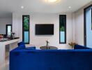 Modern living room with blue sofa and black TV on wall