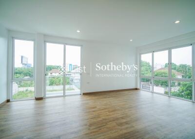 Spacious living room with large windows and wooden flooring