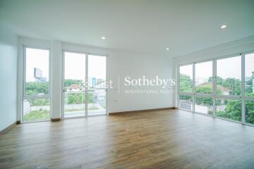 Spacious living room with large windows and wooden flooring