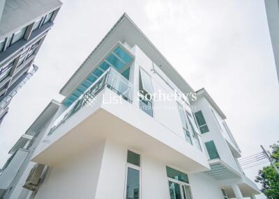 Modern white exterior of a two-story house with glass balconies