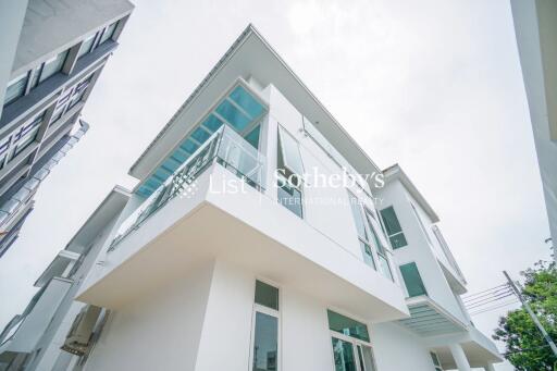 Modern white exterior of a two-story house with glass balconies