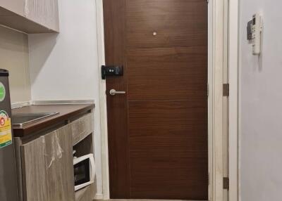 Cozy modern kitchen with wooden door, stainless steel fridge, and microwave